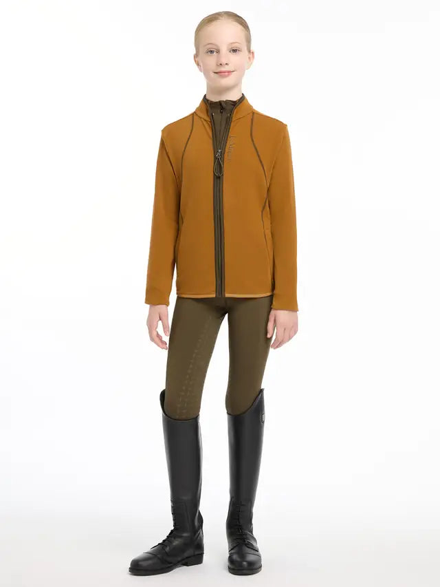 LEMIEUX Young Rider Felicity Fleece Zip Through Ginger Jacket. Equiflair. Girl in riding attire, including boots and breeches.