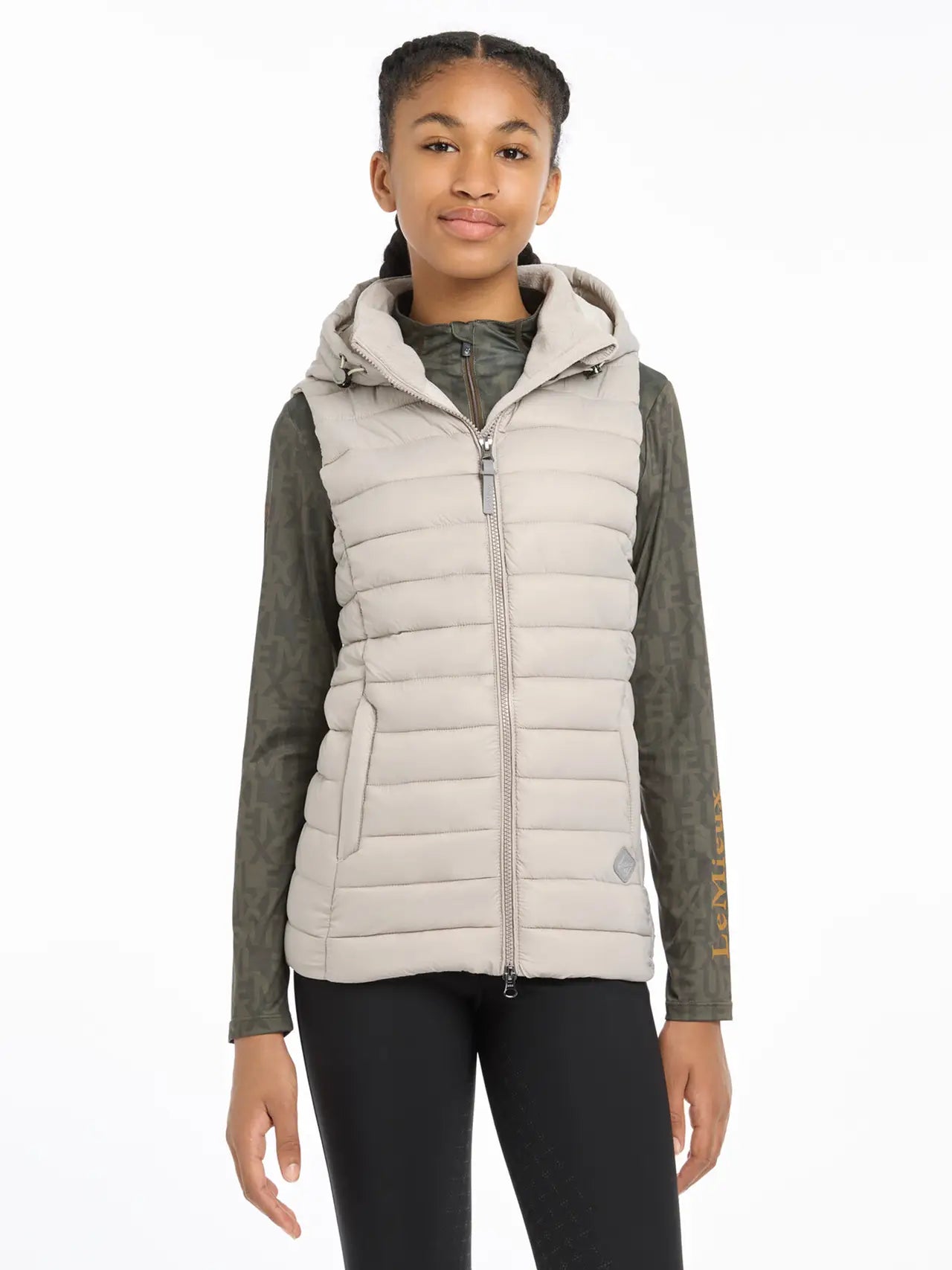 Young person in a LEMIEUX Milly Puffer Gilet - Ash color, perfect for equestrian activities. Youth apparel.