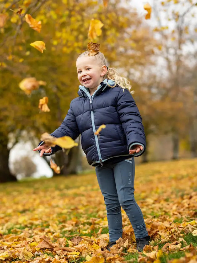 LEMIEUX MINI MEGAN Reversible Puffer Navy - Children's Winter Coat from Equiflair. Girl playing with leaves in Autumn.
