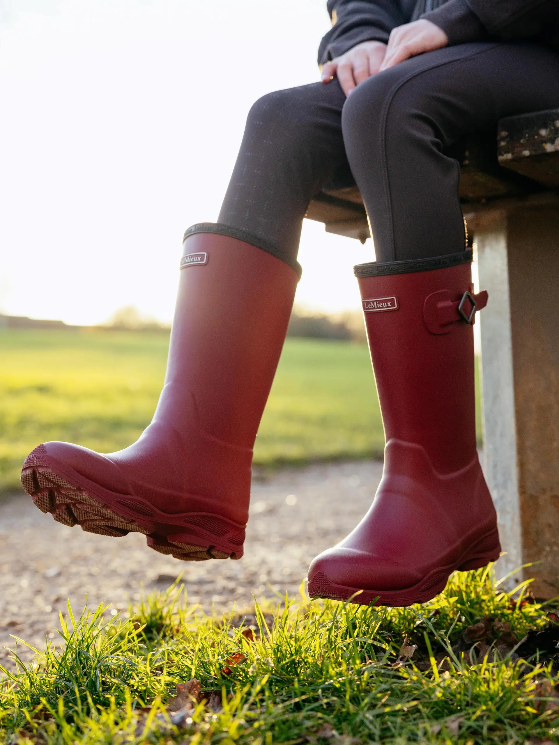 LEMIEUX Young Rider Ultra Stride Wellies Ember: Waterproof equestrian riding boots with adjustable calf fit, shown outdoors.