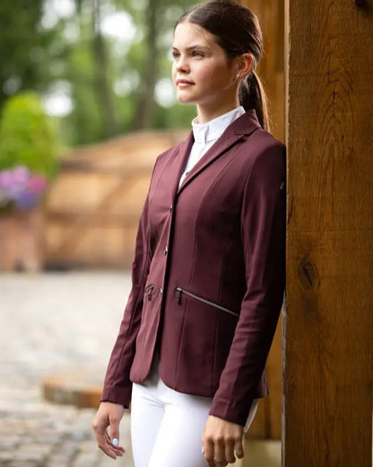 LeMieux Junior Pro Show Jacket Burgundy: Equestrian competition apparel for young riders. Burgundy jacket with white riding pants.
