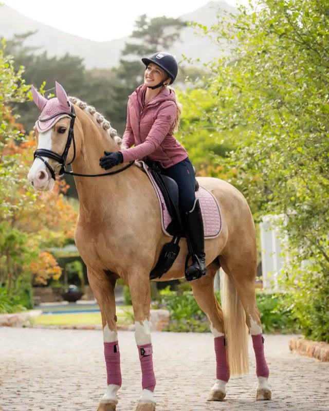 Equestrian: Horse & Rider in Dressage Attire with a LeMieux Suede Dressage Square Blossom (Pink) Saddle Pad. 