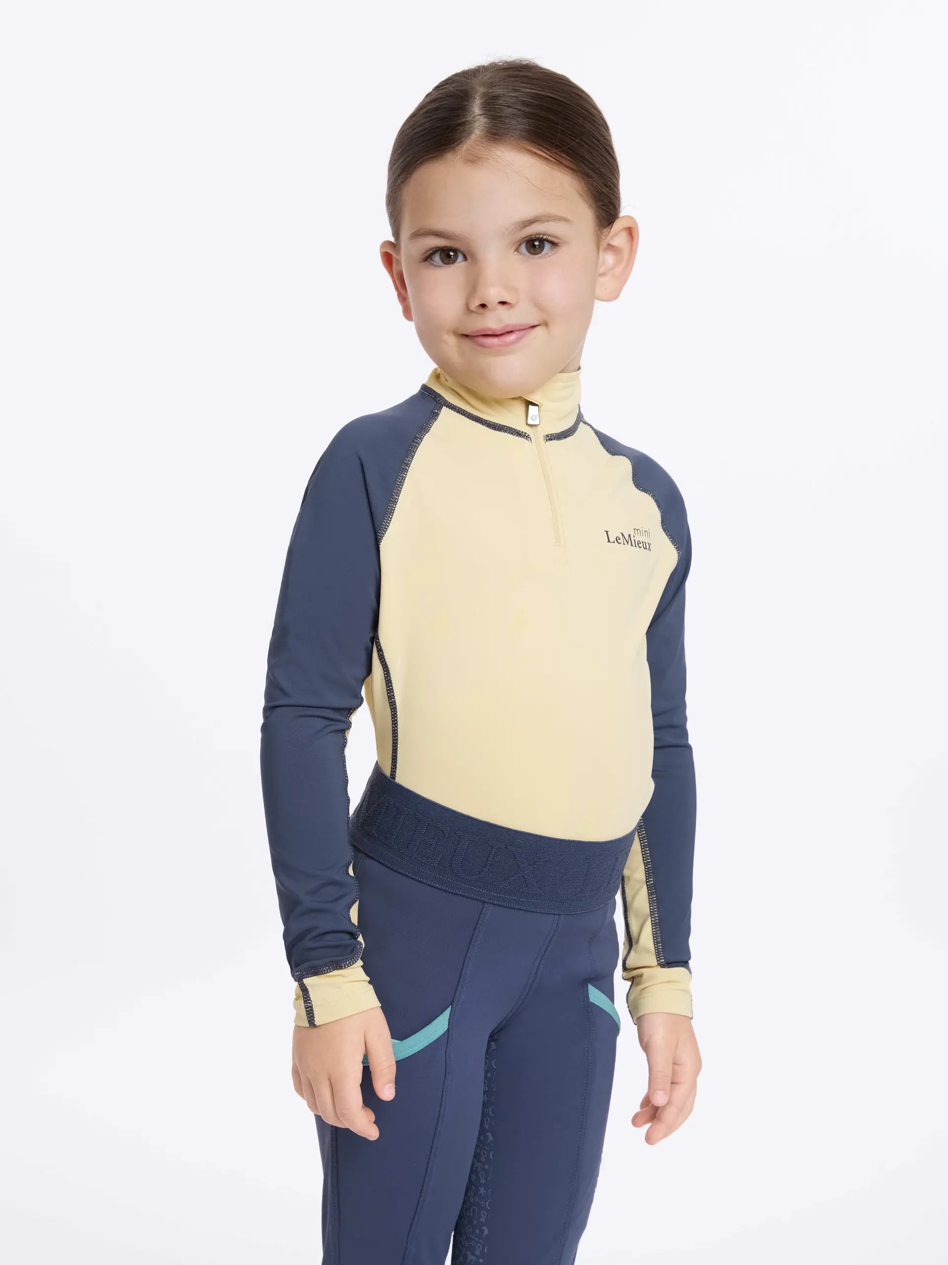 Lemieux Mini Base Layer: Girl in equestrian apparel. Comfortable & stylish horse riding top by Lemieux.