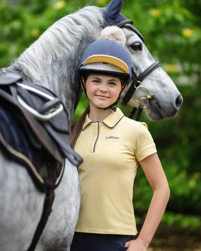 Girl in Lemieux Pom Hat Silk Dusk/Mimosa riding horse. Horse riding fashion and style. 