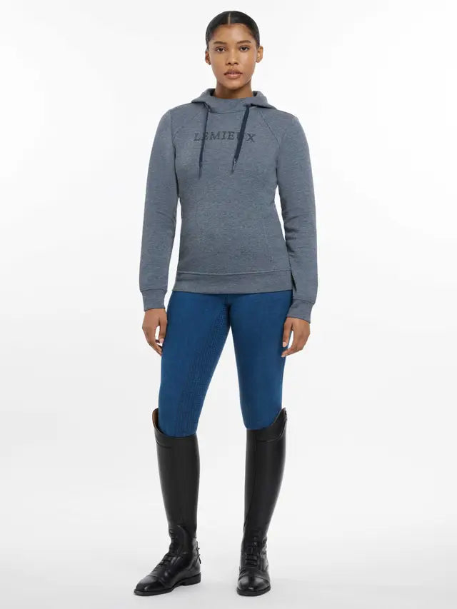 LeMieux Martha Hoodie in Dusk Blue: Woman wearing equestrian clothing, leggings and boots. Stylish riding apparel