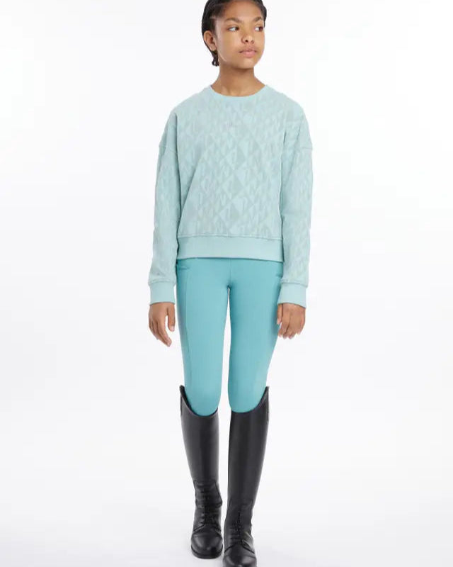 LeMieux Young Rider Clea Aqua Sweater: Girl in riding boots and monogram sweatshirt. Equestrian fashion by Equiflair.