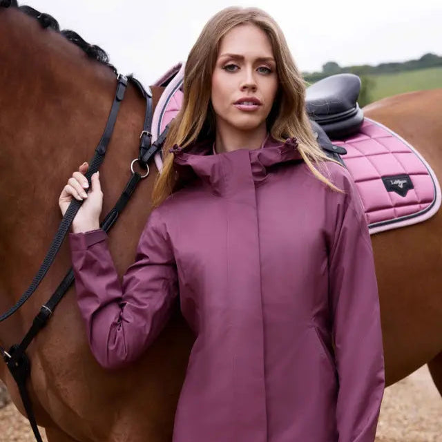 LeMieux Isla Rosewood Waterproof Jacket Equestrian Fashion. Woman wearing coat by a horse, Equiflair store.