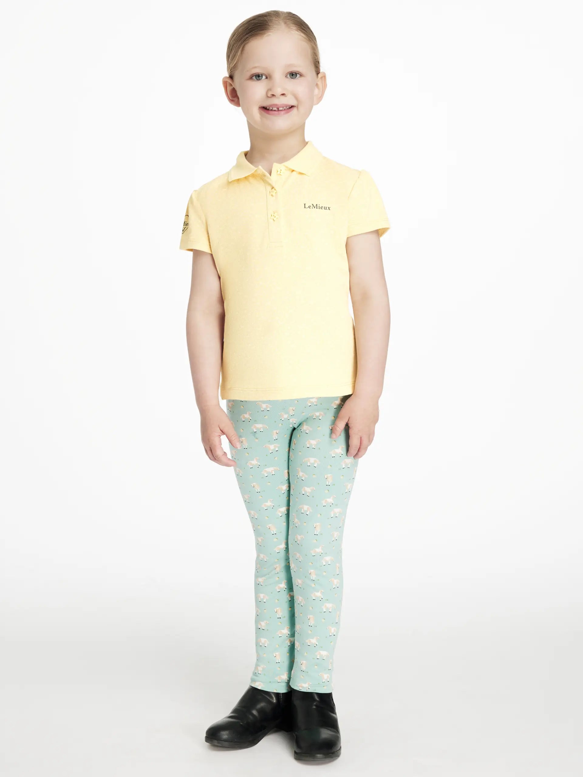 Girl wearing Lemieux lemon polo and sheep patterned riding leggings, equestrian kids apparel
