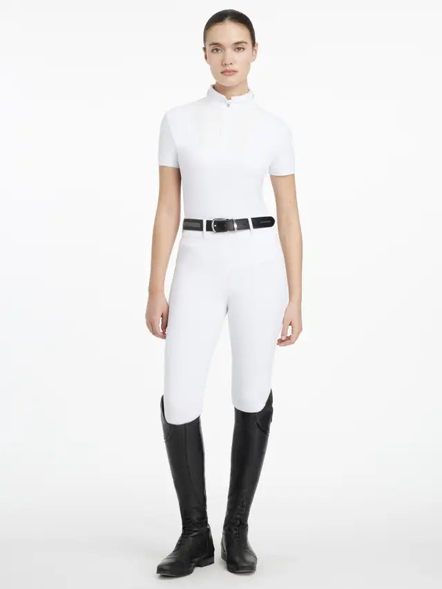 LeMieux White Equestrian Show Shirt Outfit: Woman in Short Sleeve Top, White Breeches, Black Belt & Riding Boots for Horse Shows