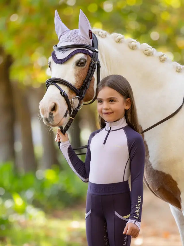 LEMIEUX Mini Base Layer in Lilac: Young girl with horse in matching equestrian apparel. Shop Equiflair for kids riding clothes!