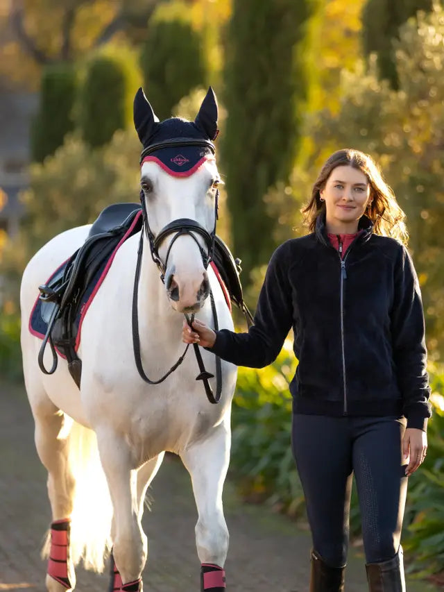 Woman leads white horse wearing Lemieux Liberty Fleece Zip Through in Navy. Equestrian apparel, Horse Riding Jacket.