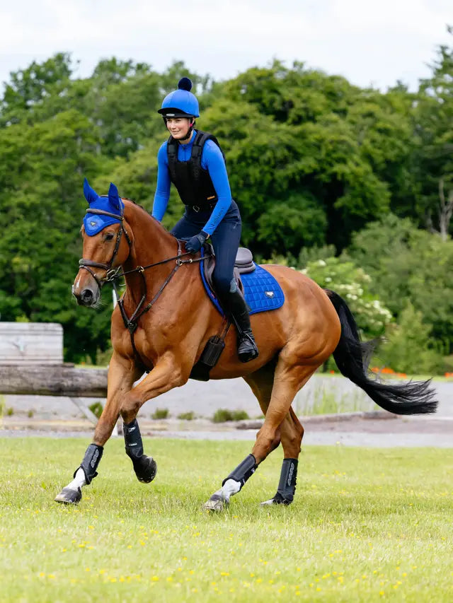 Horseback riding with Loire Classic Close Contact Square Saddle Pad in Benetton Blue. Horse eventing equestrian fashion.