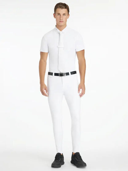 LeMieux Mens White Full Seat Sports Breech: Man in equestrian outfit, riding pants, shirt and sneakers. Competition apparel.
