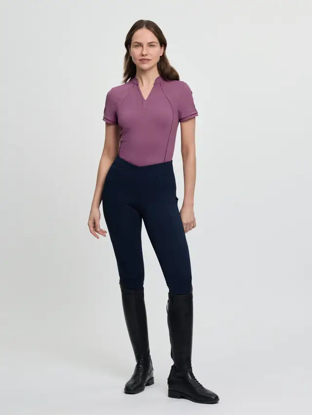 LeMieux Lisa Mesh Base Layer Mallow: Woman in technical equestrian riding top, dark pants, and black boots.