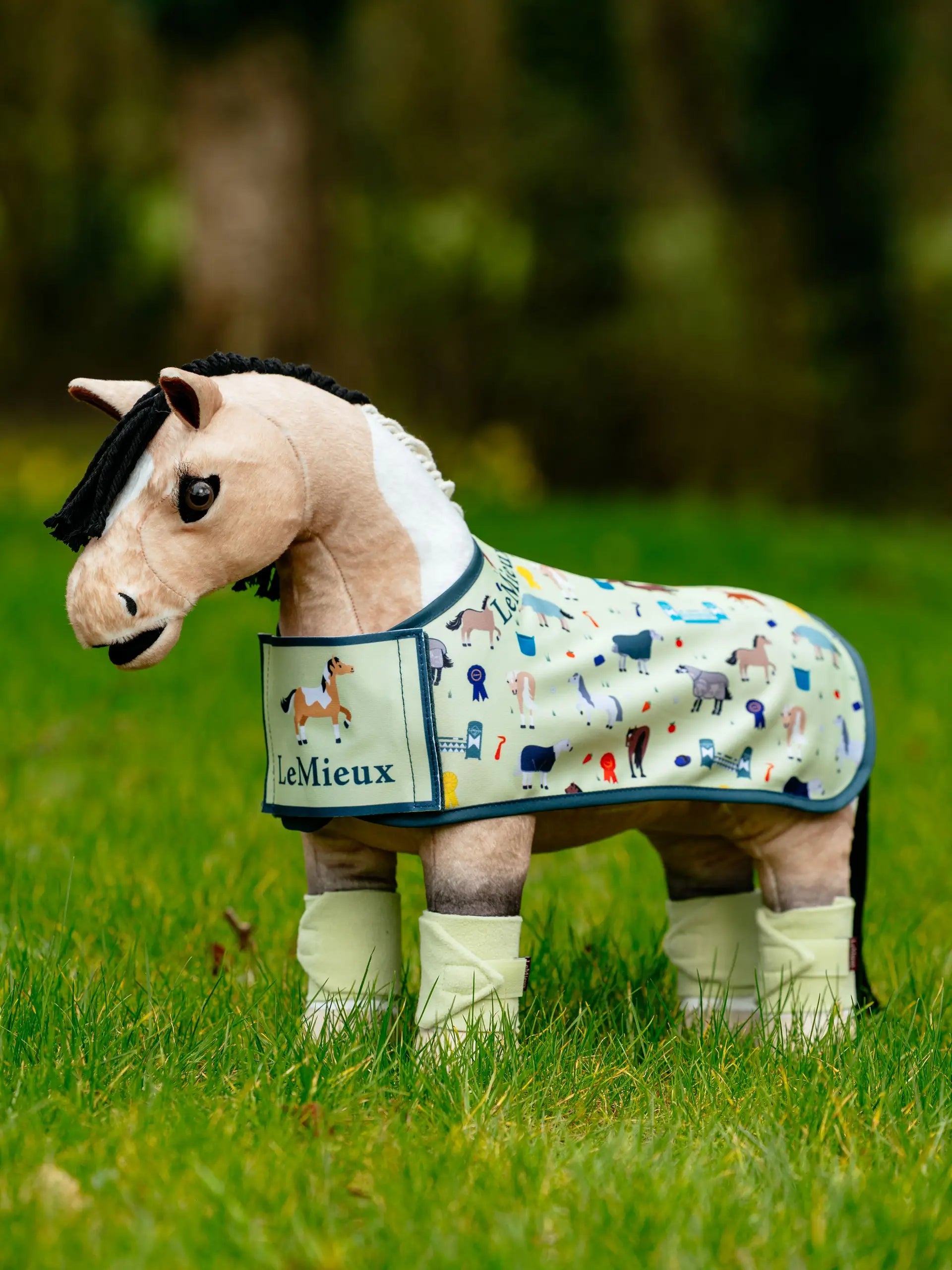 LeMieux Toy Pony Printed Rug Mallow with horse motifs and leg wraps in grass.