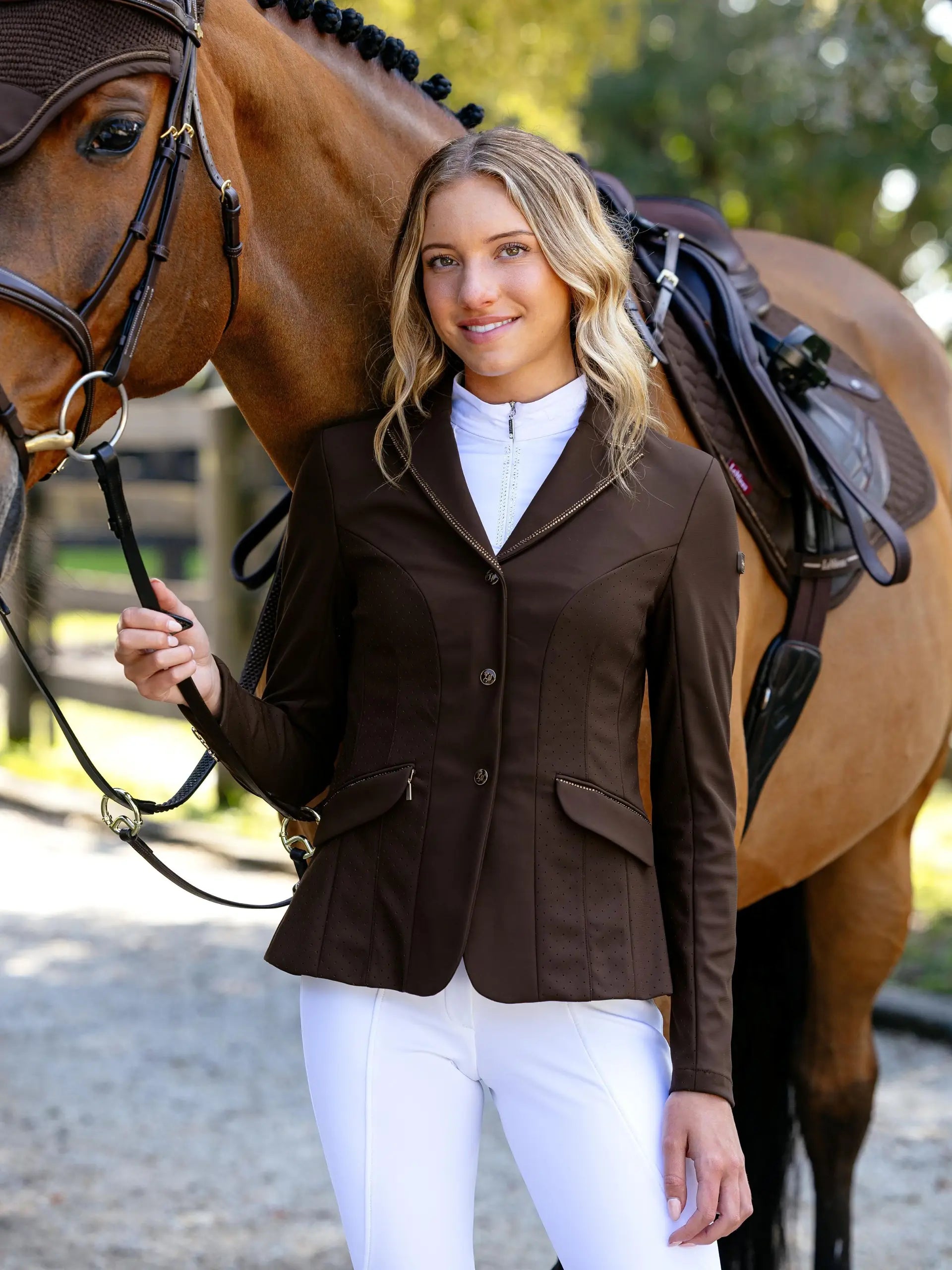 LeMieux Brilliance Diana Ladies Show Jacket Espresso: Woman in brown show jacket and white riding pants posing with a horse.