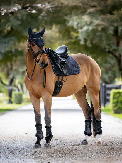 LeMieux Brilliance Dressage Saddle Pad Navy on a brown horse, complete with bridle and boots