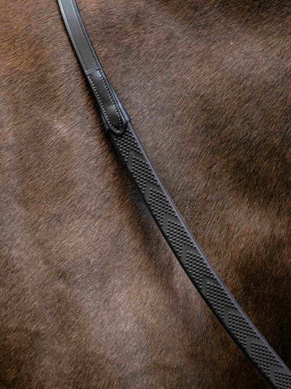 Close-up of brown horsehair with a textured black LeMieux Versa Grip rubber rein featuring dot pattern for equestrian.