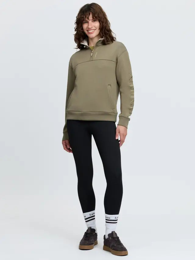 LeMieux green quarter zip sweatshirt, black leggings, women's athleisure style.