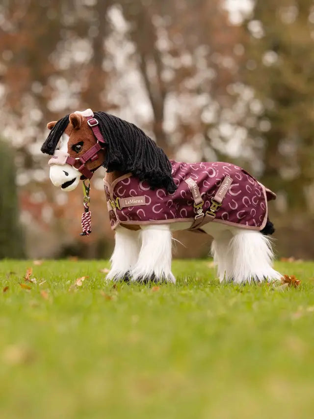 LeMieux toy pony with blackberry printed rug in an autumn outdoor setting with grass.