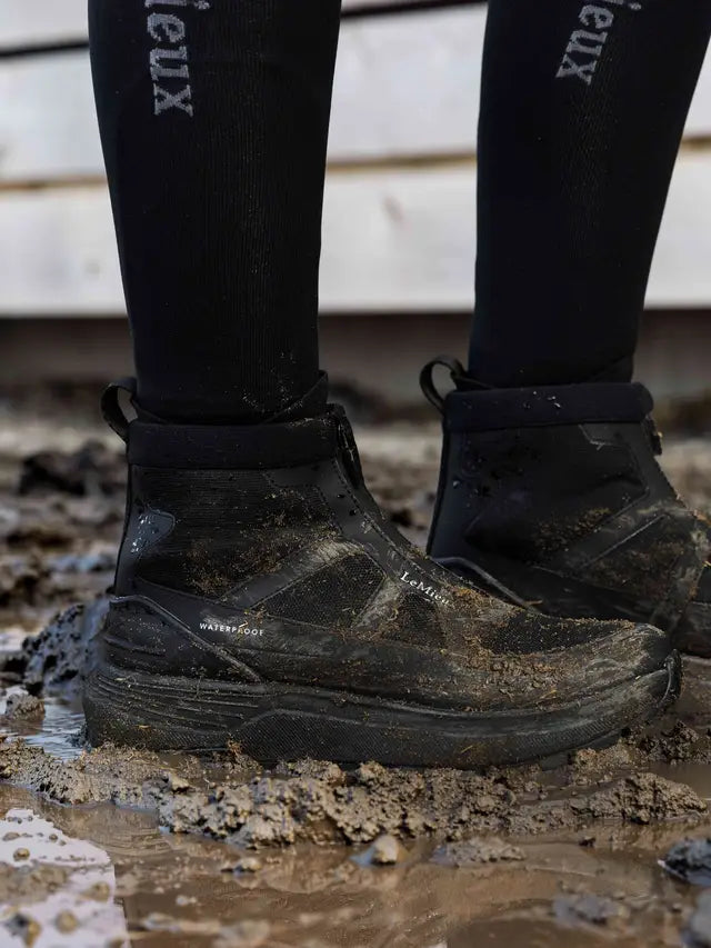 LeMieux Cavara black waterproof high top equestrian trainers with Michelin sole in mud