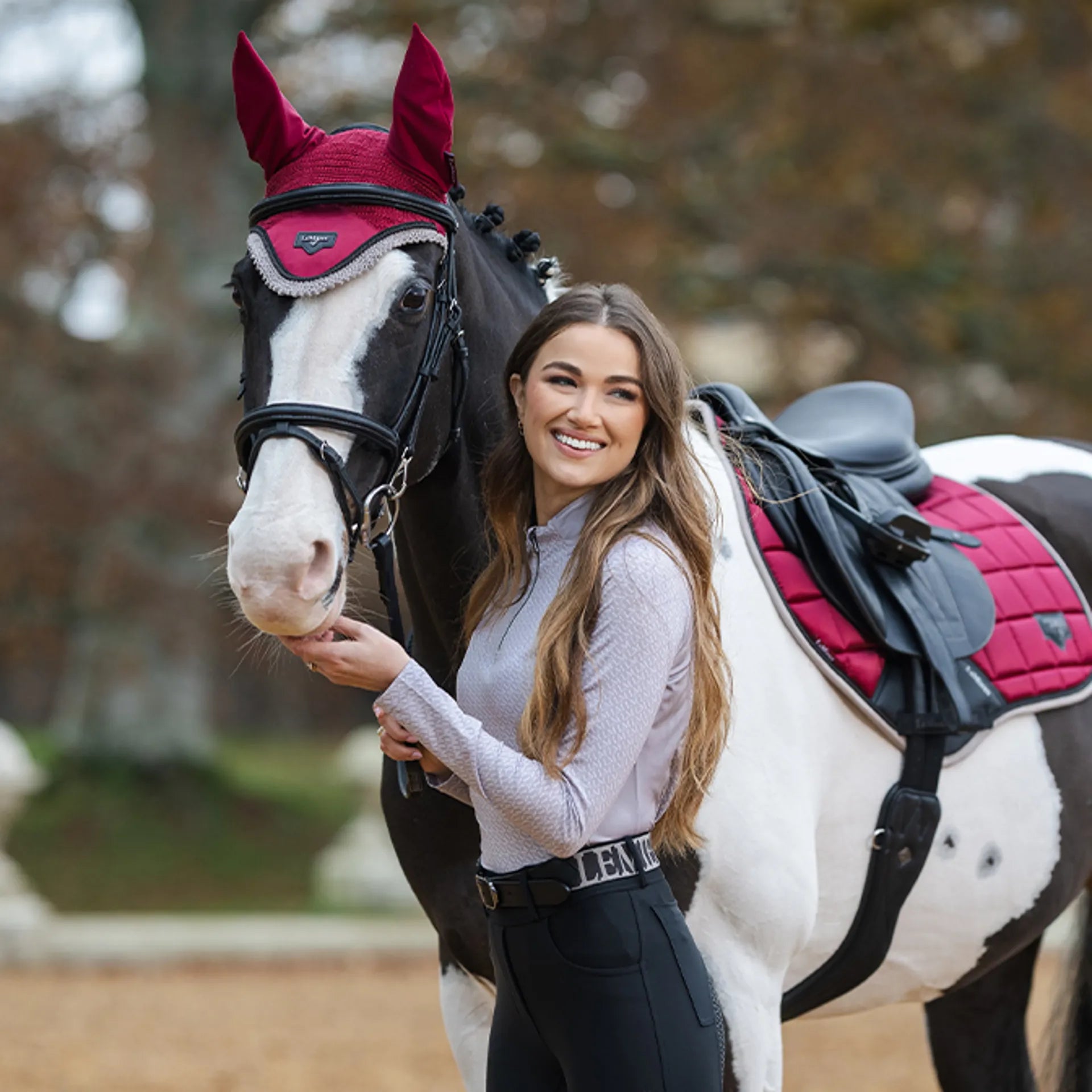 LEMIEUX Faith Base Layer Ash: UV30+ equestrian top from Equiflair. Woman & horse wearing matching burgundy saddle pad and…