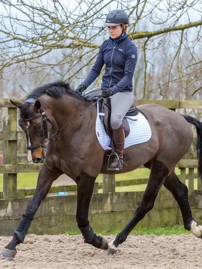 Equestrian Elegance: Woman Riding Horse with Lemieux Cotton GP Square White Saddle Pad by Equiflair
