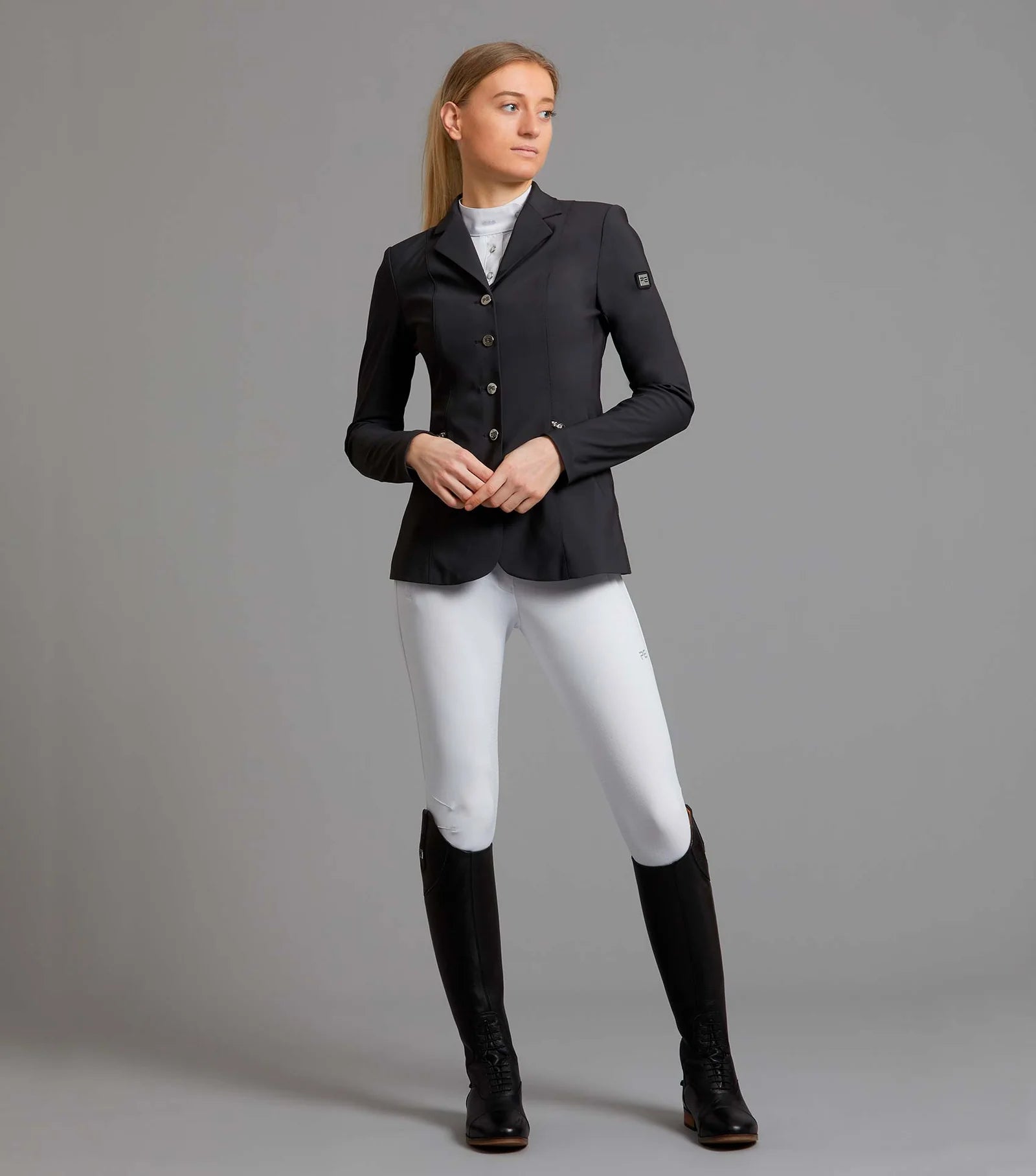 Woman in Black Premier Equine Nera Riding Jacket & White Breeches, Equiflair