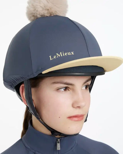 LEMIEUX POM HAT SILK DUSK/MIMOSA: Equestrian helmet cover with detachable faux fur pom pom, contrast peak, snug fit.