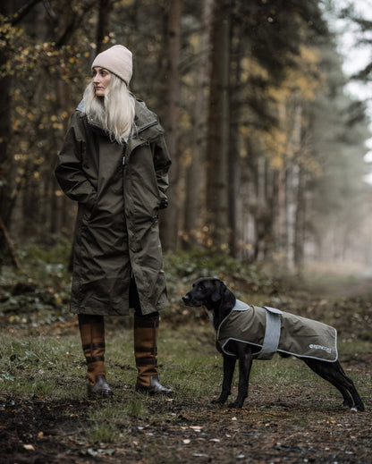 Woman & Dog in Raincoats: Waterproof REINCOAT DOG in Olive by Equiflair. Stylish, protective dog apparel in forest setting.