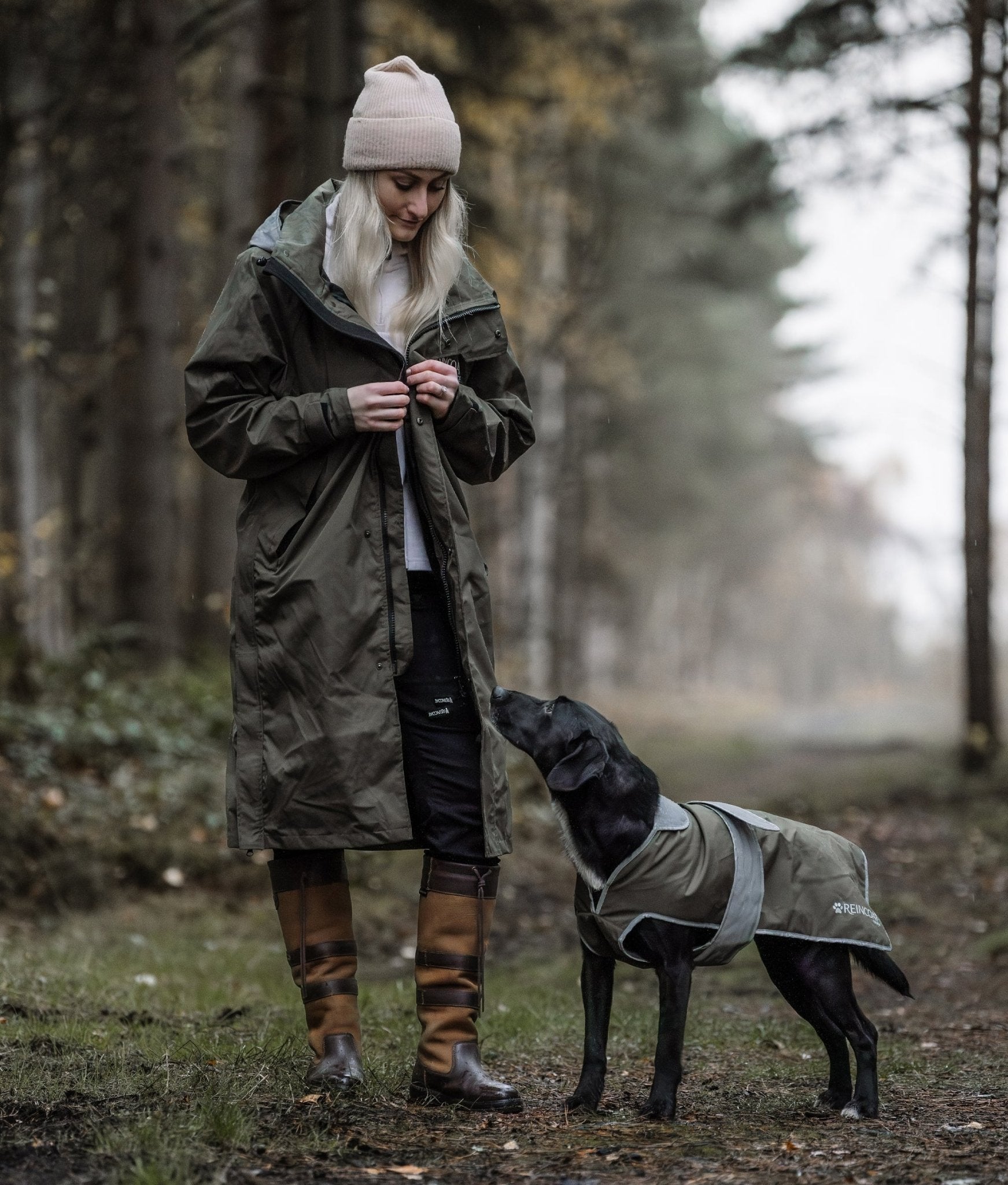 Woman in REINCOAT LITE ADULT Olive Waterproof Coat with Dog | Equiflair Outdoor Dog Walking Raincoat
