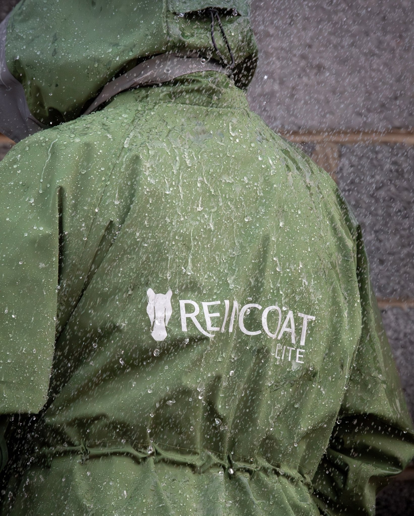 Reincoat Lite waterproof riding coat in rain. Equestrian riding coat with reflective detail, perfect for horse riding in wet weather.