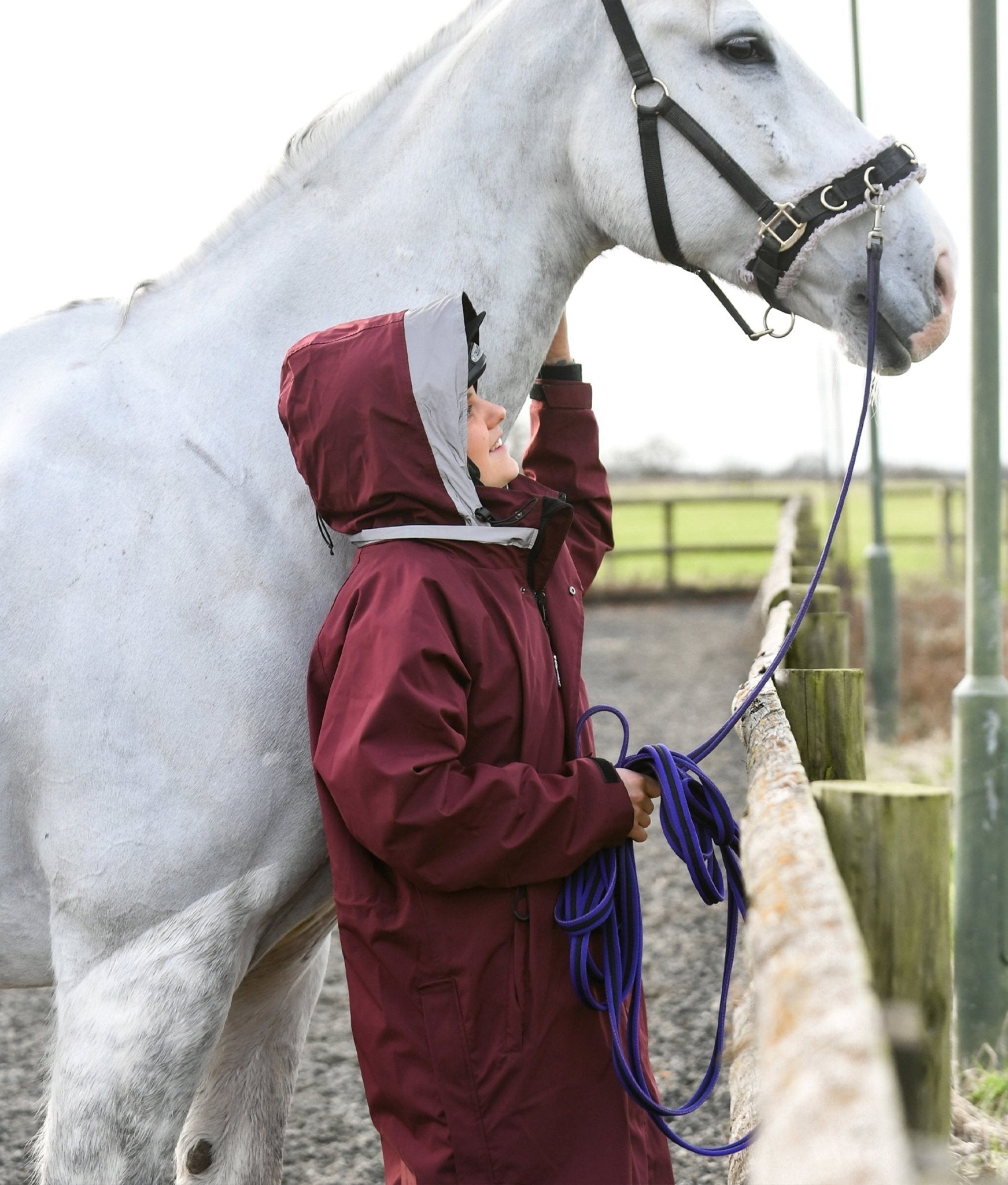 Horse Riding: Woman with White Horse in Equiflair Waterproof Jacket. Reincoat Lite Adult - Pink. Equiflair.