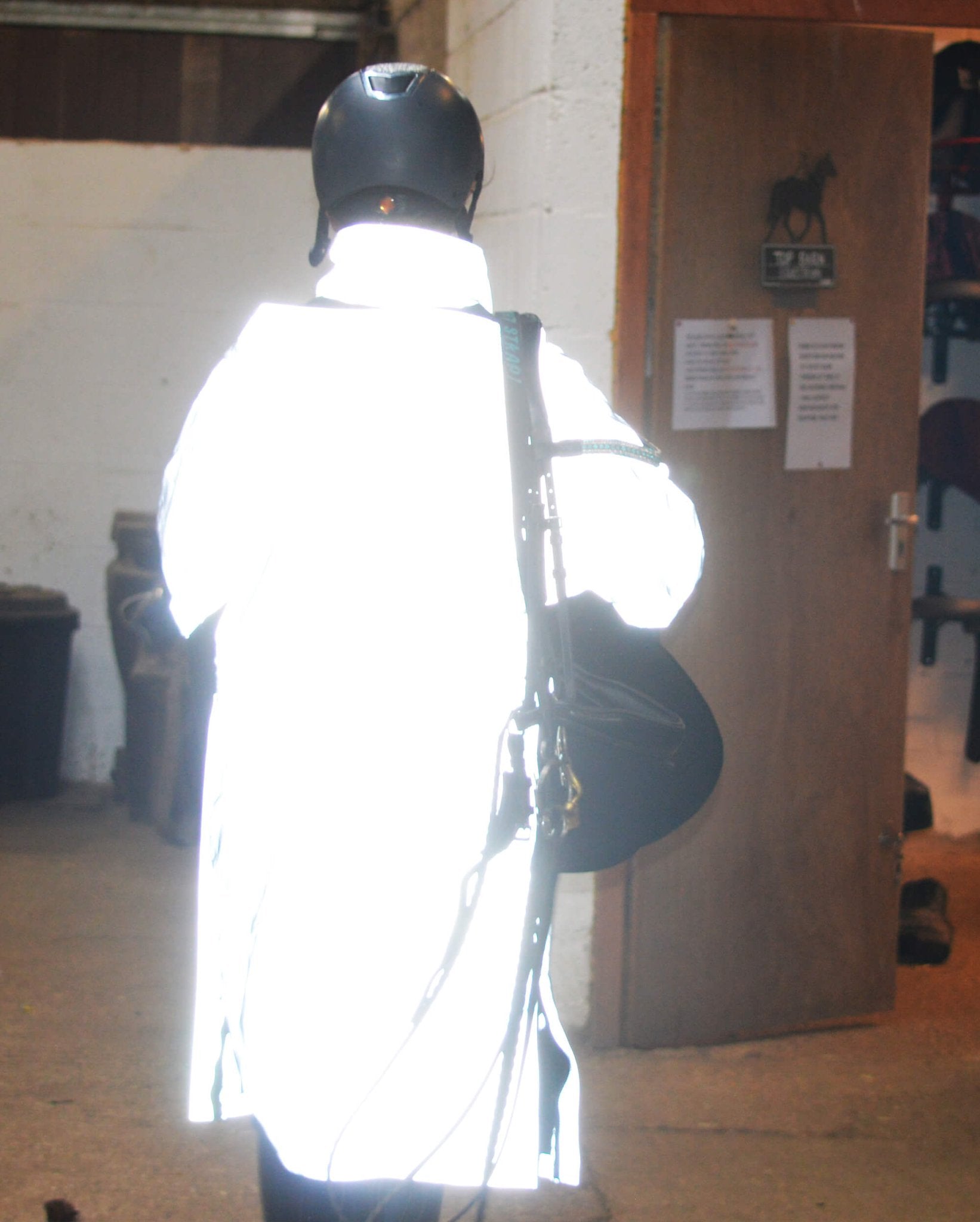 Reflective Reincoat Lite Kids by Equiflair: Back view of kid wearing hi-vis safety rain jacket for horse riding.