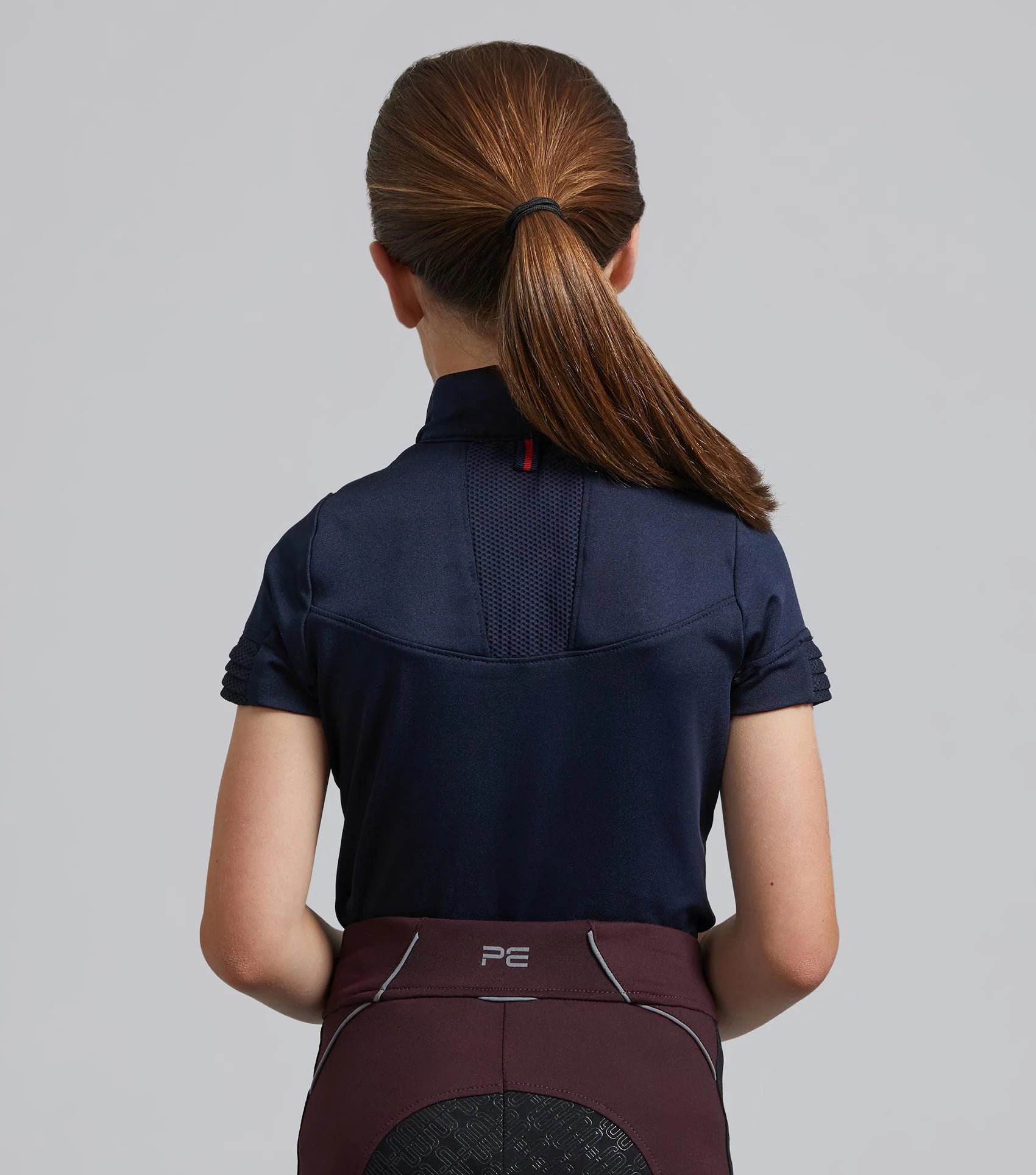 Girl in Premier Equine Navy Riding Top. Equestrian Apparel, Short Sleeve Technical Shirt, Moisture Wicking, Girl's Clothing, Riding Outfit