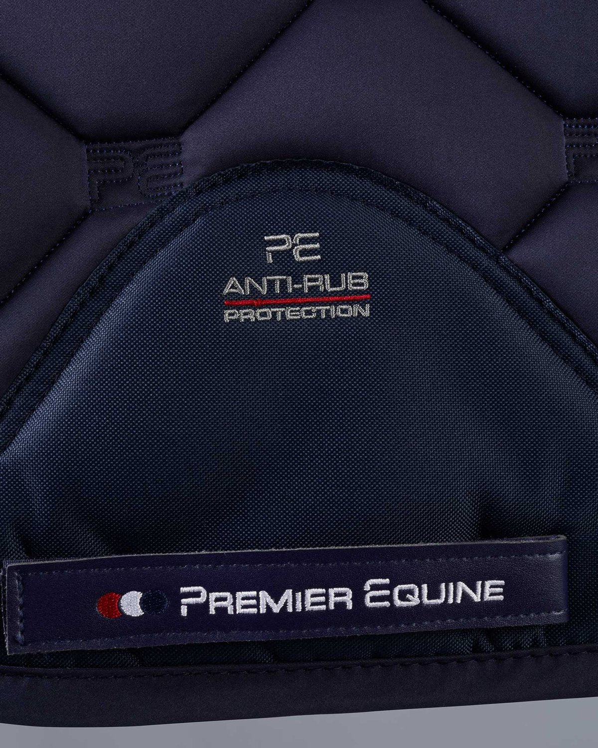 PREMIER EQUINE Saltare Dressage Square - Navy Close-Up: Logo, Quilting, & Anti-Rub Protection