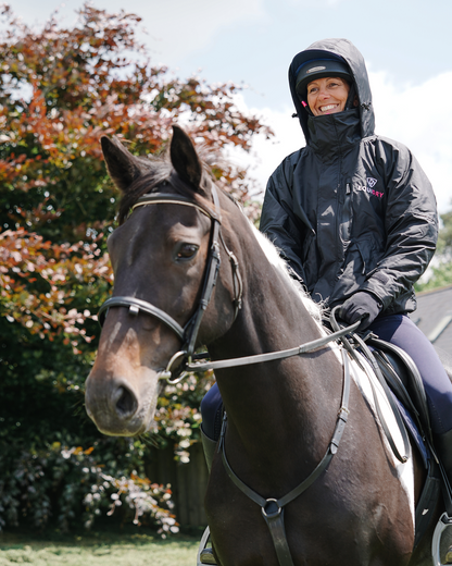 EQUIDRY women's waterproof short blouson style horse riding jacket in black/peacock pink being shown on horse
