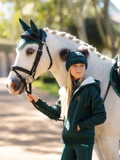Girl in LEMIEUX MINI SHERPA LINED LILY HOODIE SPRUCE with horse. Equestrian fashion, comfortable, warm.