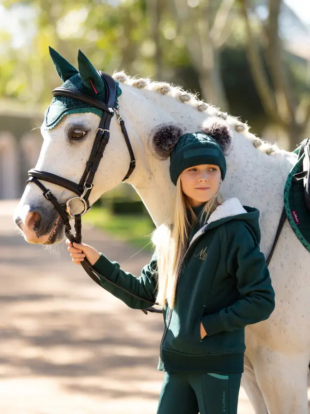 Girl in LEMIEUX MINI SHERPA LINED LILY HOODIE SPRUCE with horse. Equestrian fashion, comfortable, warm.