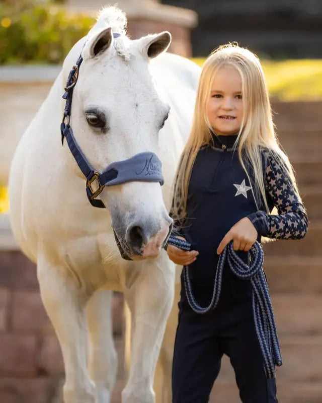 Girl & White Pony Wearing LEMIEUX Mini Base Layer from Equiflair - Reflective Star Equestrian Apparel for Kids