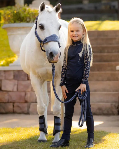 Girl with White Pony wearing LeMieux Equestrian Gear - Star Print Base Layer Riding Outfit