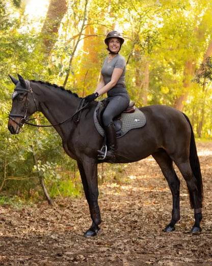 Woman on horse with LeMieux Earth GP Square Moss saddle pad from Equiflair. Eco-friendly green general purpose horse riding equipment.