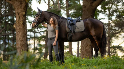LEMIEUX EARTH Dressage Saddle Pad in MOSS from Equiflair: Stylish & Sustainable Horse Riding Gear. Woman with horse.