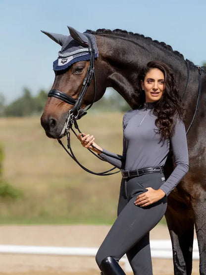 LeMieux Loire Fly Hood Twilight Grey. Woman standing next to horse wearing the fly hood. Equestrian fashion