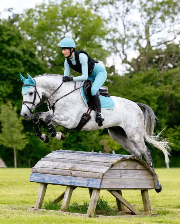 Horse Jumping Fence with Rider wearing LEMIEUX SUEDE CLOSE CONTACT SQUARE LAGOON saddle pad from Equiflair